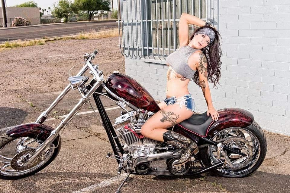 Woman posing on a custom chopper motorcycle outdoors with Marie's Headband.